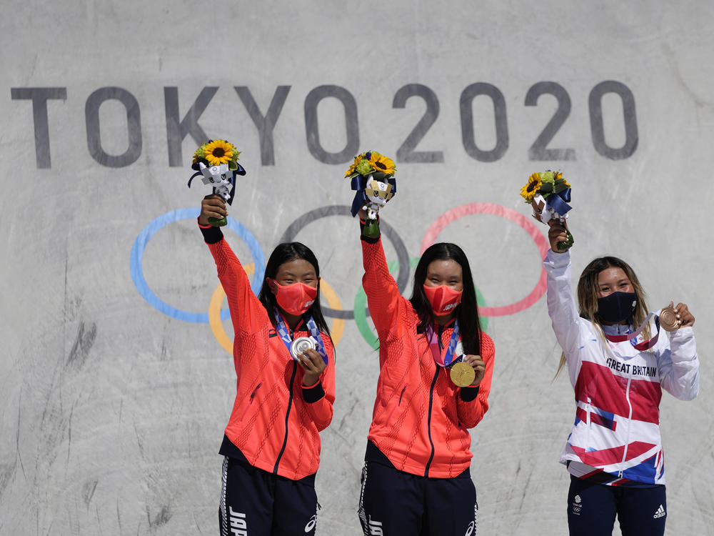 Silver medalist Kokona Hiraki of Japan (from left), gold medalist Sakura Yosozumi of Japan and bronze medalist Sky Brown of Britain pose during a medals ceremony for the women's park skateboarding at the Tokyo Olympics on Wednesday.