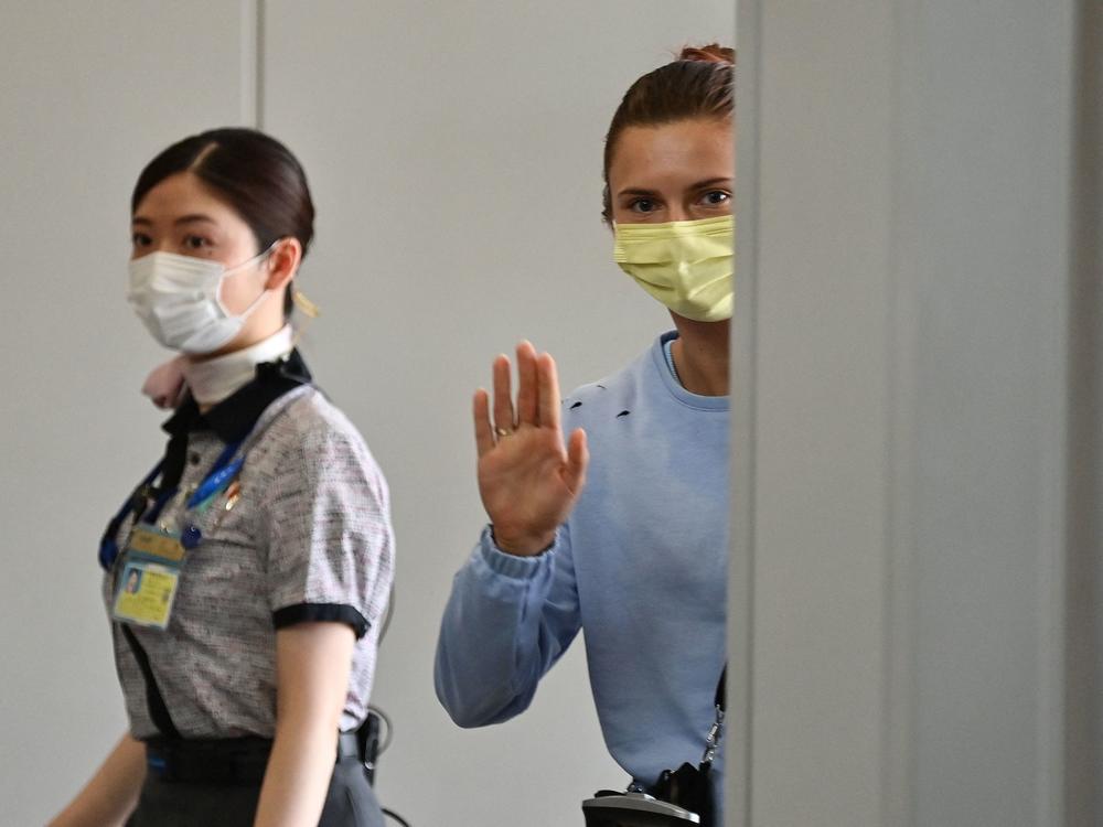 Belarus athlete Kristina Timanovskaya waves as she boards a Vienna-bound flight at Narita International Airport outside Tokyo on August 4, 2021.