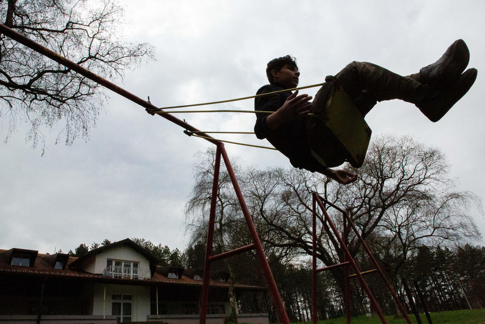 Mohammad Bilal, 17, from Afghanistan, plays on a swing at Bogovadja asylum center in central Serbia. He reached Serbia alone after smugglers in Iran put him in the trunk of a car alongside four other children with no water and amid scorching temperatures. 