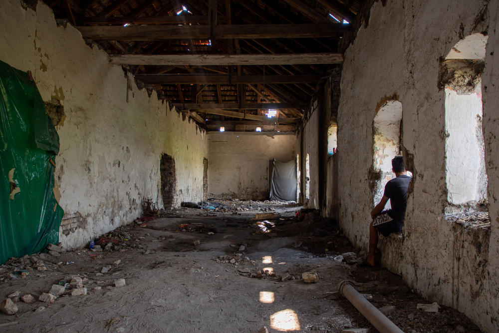 A man from Afghanistan sits in an abandoned farm building on the outskirts of the Serbian village of Horgos, along the Hungarian border. He says that when Hungarian authorities apprehended him on the border, they forced him to stand for 10 hours, threatening to unleash snarling dogs on him.