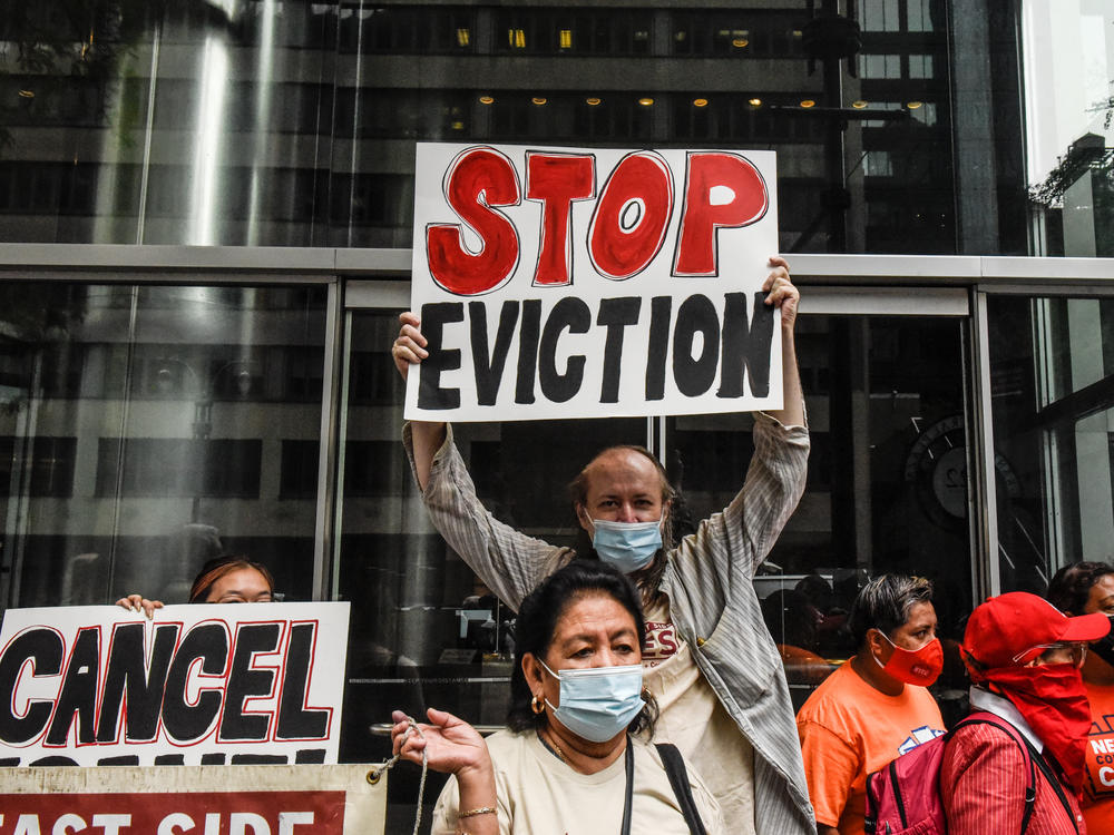 People hold signs opposing evictions on Thursday in New York City.