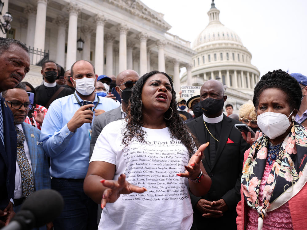 Rep. Cori Bush, D-Mo., (center) speaks at a rally at the U.S. Capitol on Tuesday. Bush slept on the steps of the Capitol for days to protest that the CDC's eviction moratorium was being allowed to expire.