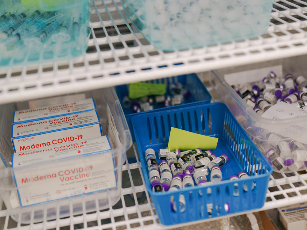 Moderna and Pfizer COVID-19 vaccines sit in a refrigerator at a mass vaccination site in June in Cranston, R.I. As demand for vaccines lags in the U.S., expiration dates loom. At the same time, lower-income countries are eager for more doses as infections rise.