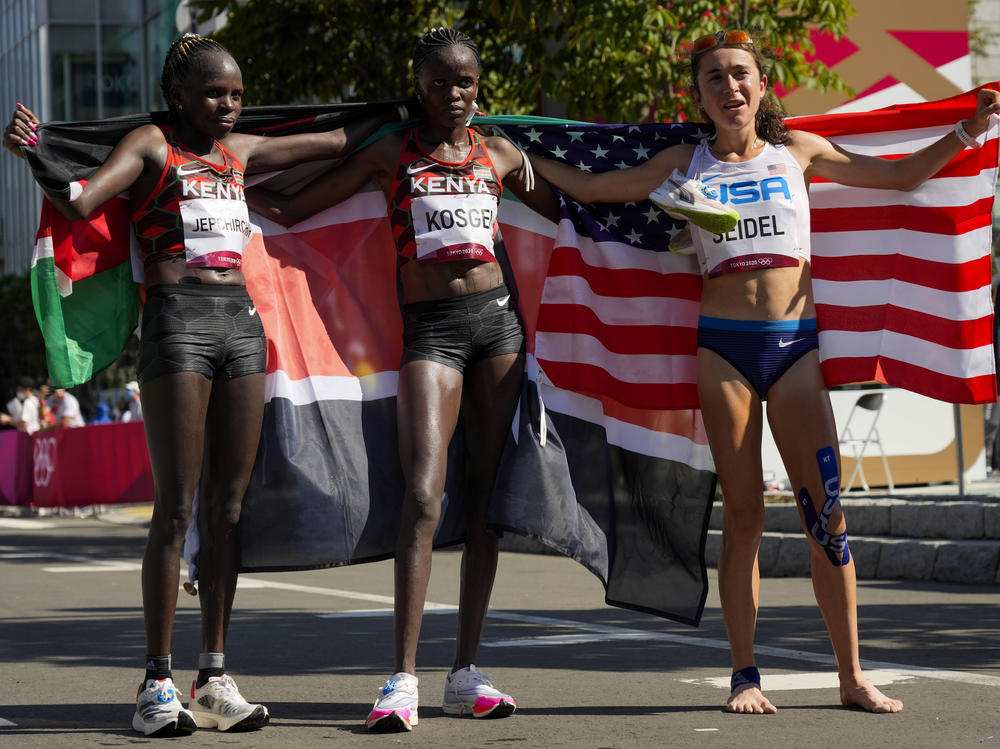 Gold medalist Peres Jepchirchir (left) of Kenya, stands with silver medalist and compatriot Brigid Kosgei, (center) and bronze medalist Molly Seidel (right) of the United States, after the women's marathon at the Summer Olympics in Sapporo, Japan.