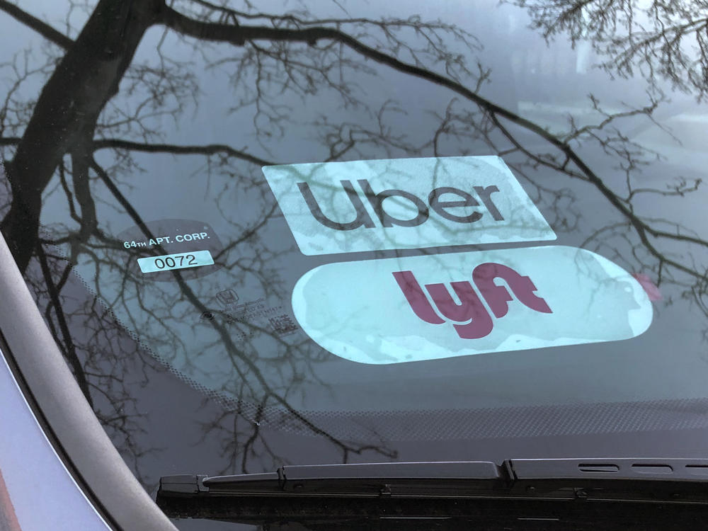 Uber and Lyft sign in windshield of car, Queens, New York.
