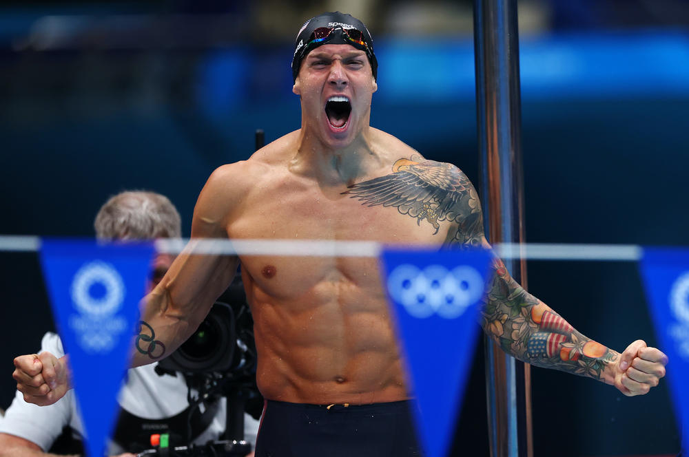 U.S. swimmer Caeleb Dressel celebrates after winning the gold medal and breaking the world record in the men's 4 x 100m medley relay final at the Tokyo Olympics.