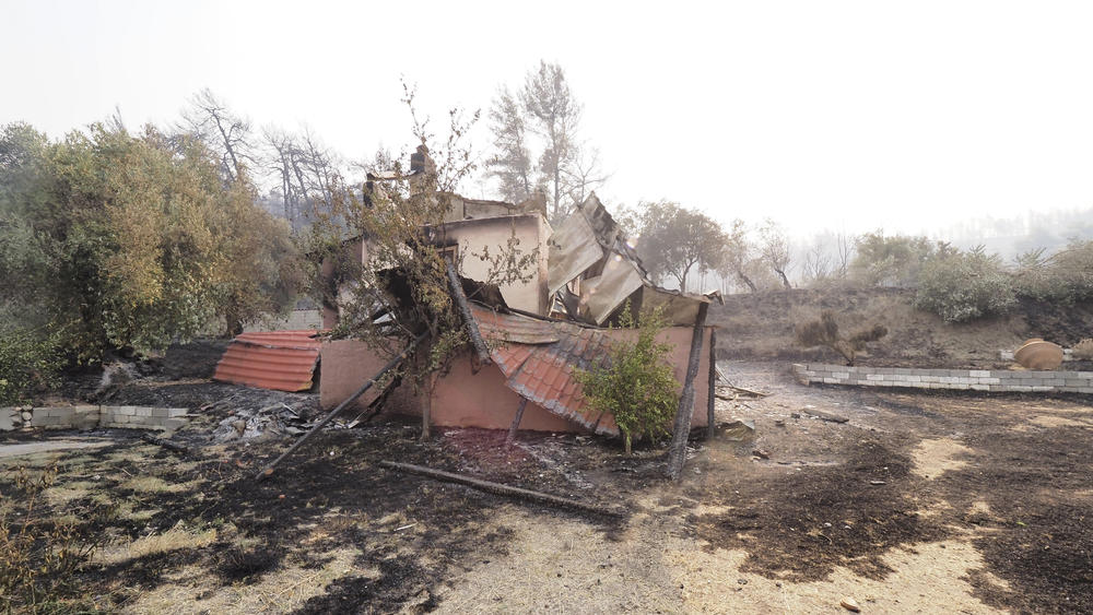 A burned building is seen in Limni village on the island of Evia, Greece on Saturday. Wildfires rampaged through massive swathes of Greece's last remaining forests for yet another day Saturday, encroaching on inhabited areas and burning scores of homes, businesses and farmland.