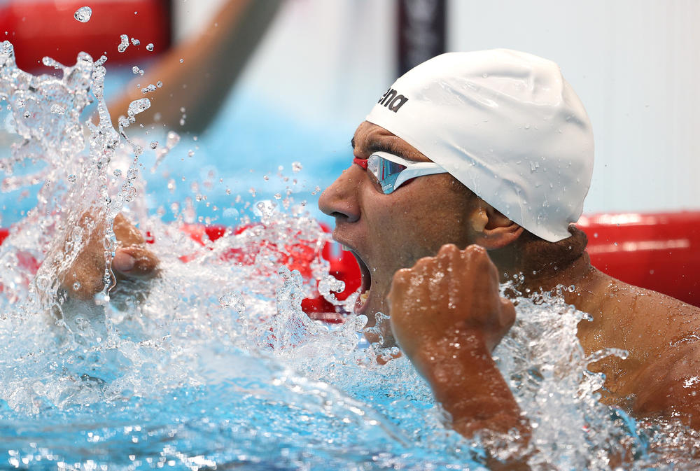 Tunisian swimmer Ahmed Hafnaoui celebrates after winning the gold medal in the men's 400 meter freestyle final.