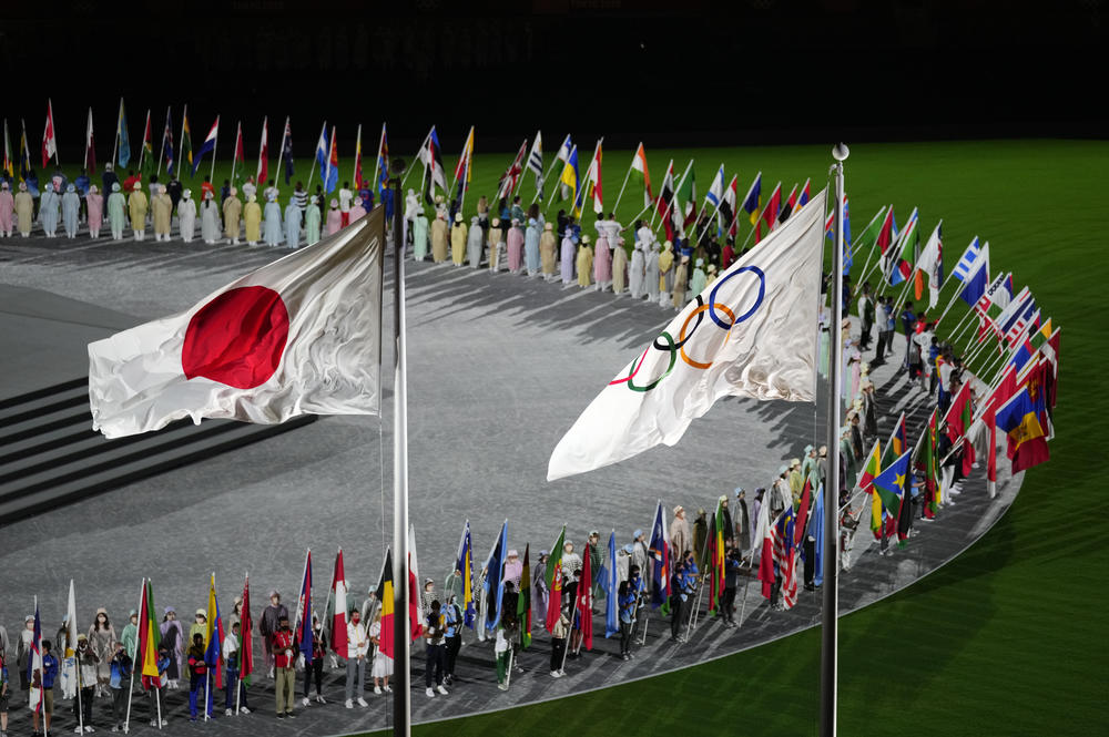 The Japan and Olympic flags fly as country flags are carried in during the closing ceremony.
