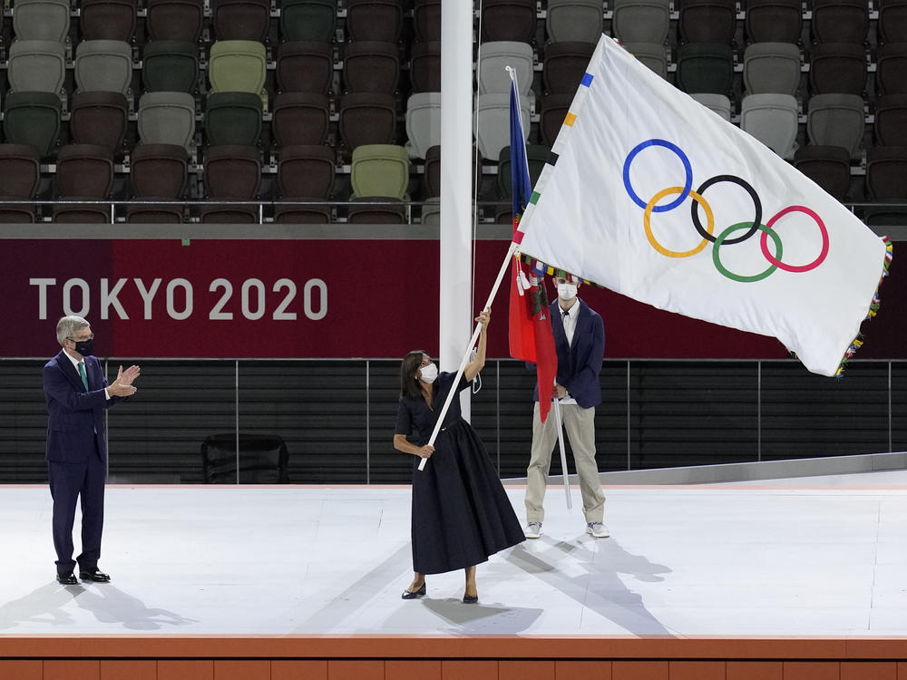 Paris mayor Anne Hidalgo, right, holds the Olympic flag during the closing ceremony in the Olympic Stadium at the 2020 Summer Olympics, Sunday, Aug. 8, 2021, in Tokyo, Japan.