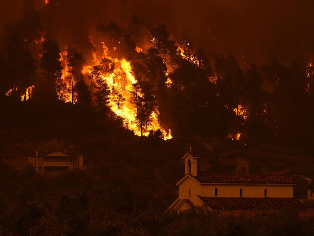 Flames approaching Gouves village on the island of Evia, about 115 miles north of Athens, on Sunday.