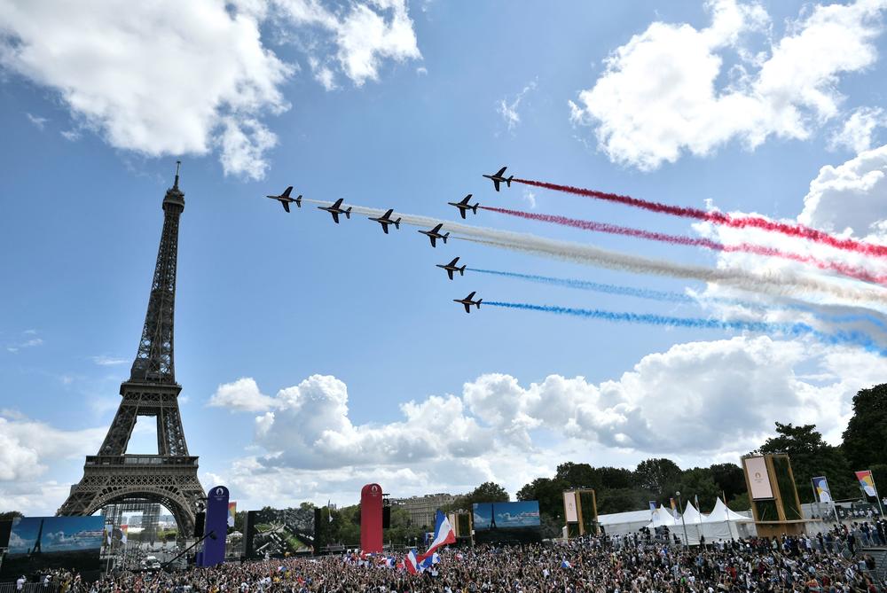 French aerial patrol 'Patrouille de France' fly over the fan village of The Trocadero set in front of The Eiffel Tower, in Paris on August 8, 2021 upon the transmission of the closing ceremony of the Tokyo 2020 Olympic Games.