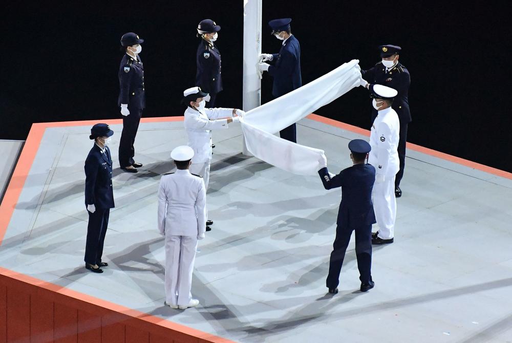 The Olympic flag is folded during the closing ceremony.