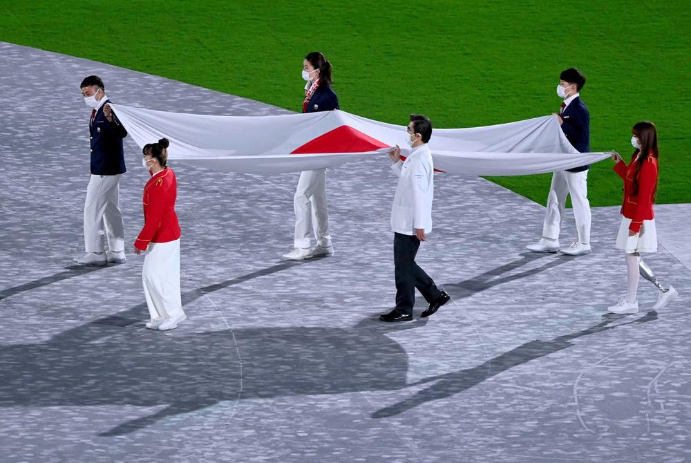 The Japanese flag is brought into the stadium.