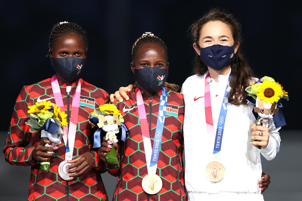 Silver medalist Brigid Kosgei, left, of Team Kenya, gold medalist Peres Jepchirchir, center, of Team Kenya and bronze medalist Molly Seidel of Team United States pose during the medal ceremony for the Women's Marathon Final during the Closing Ceremony of the Tokyo 2020 Olympic Games.