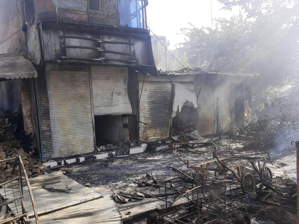 Smoke rises from damaged shops after fighting between Taliban and Afghan security forces in Kunduz city, northern Afghanistan, on Sunday, Aug. 8.