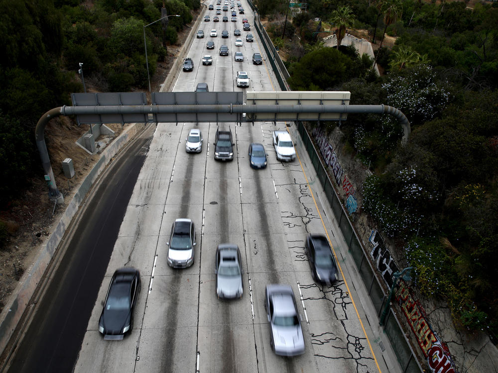 Cars drive down the 110 Freeway toward downtown Los Angeles, California in April 2021. President Biden has pledged to cut U.S. greenhouse gas emissions in half by 2030.