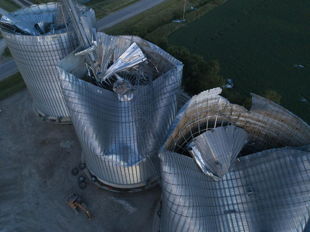 Damaged grain bins are shown at the Heartland Co-Op grain elevator on Aug. 11, 2020, in Malcom, Iowa. Some people are still recovering a year after the 2020 derecho caused $11 billion in damage across the Midwest.