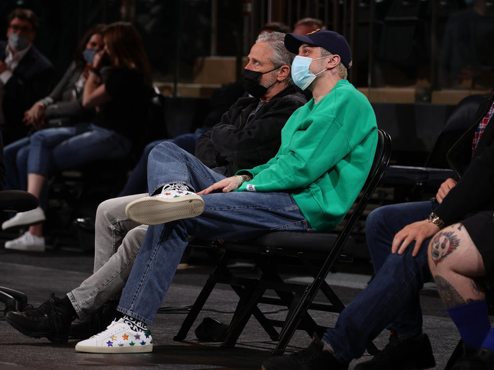 Jon Stewart and Pete Davidson sit court-side at a New York Knicks game on April 21, 2021 at Madison Square Garden in New York City, New York. They will hold a comedy special to benefit 9/11 charities there in September.