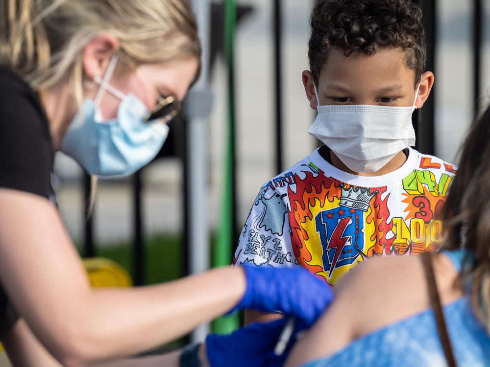 A child watches as a nurse administers a COVID-19 vaccine during a pop-up vaccination event in April at Lynn Family Stadium in Louisville, Ky.