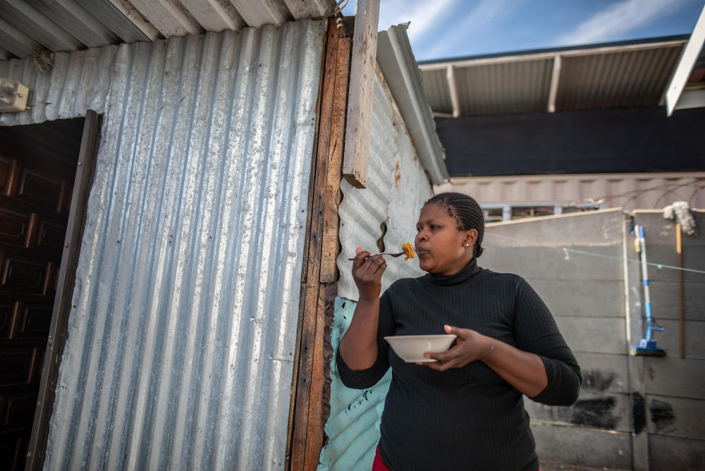 Aviwe Maphini, 30, eats pasta with canned sardines in front of her home in Cape Town, South Africa. The mom of two was working as a lawyer before the pandemic hit.