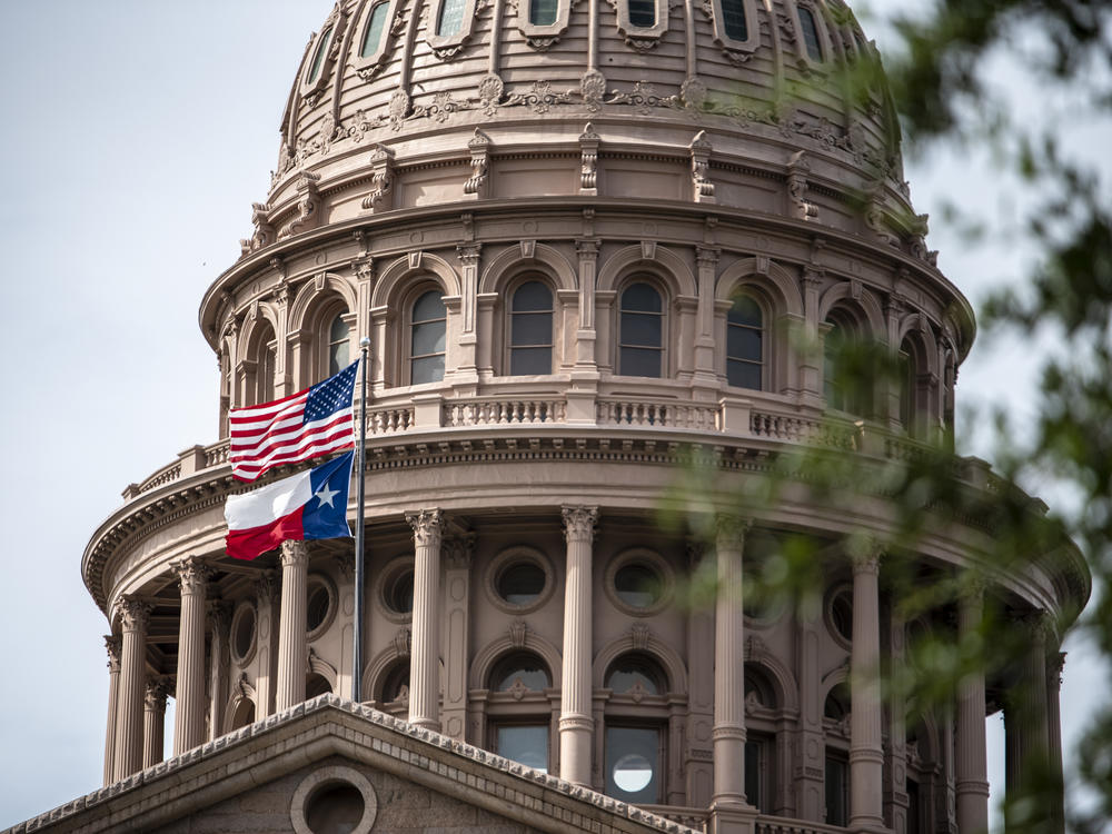 The U.S. and Texas flags fly outside the state Capitol last month in Austin.