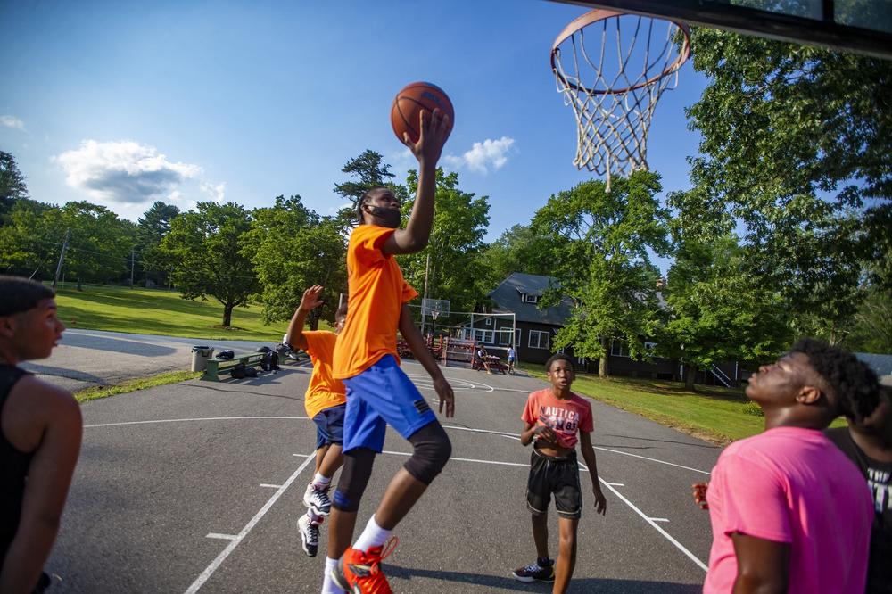 Joshua-Mark Campbell, 17, goes up for a layup while playing basketball with other boys at Camp Atwater.