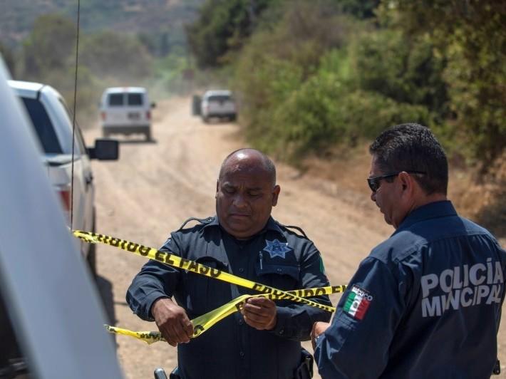 Officers hold a police cordon at the scene where two young American children were found dead in Rosarito in the Mexican state of Baja California on Monday.