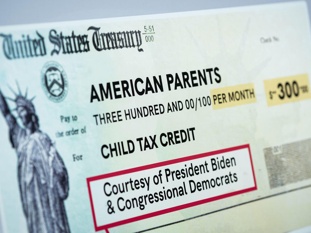 A child tax credit poster is displayed during a news conference in Washington, D.C., on July 15. Early data shows that after the child tax credit payments went out this summer, the number of households with children who experience food insufficiency dropped.