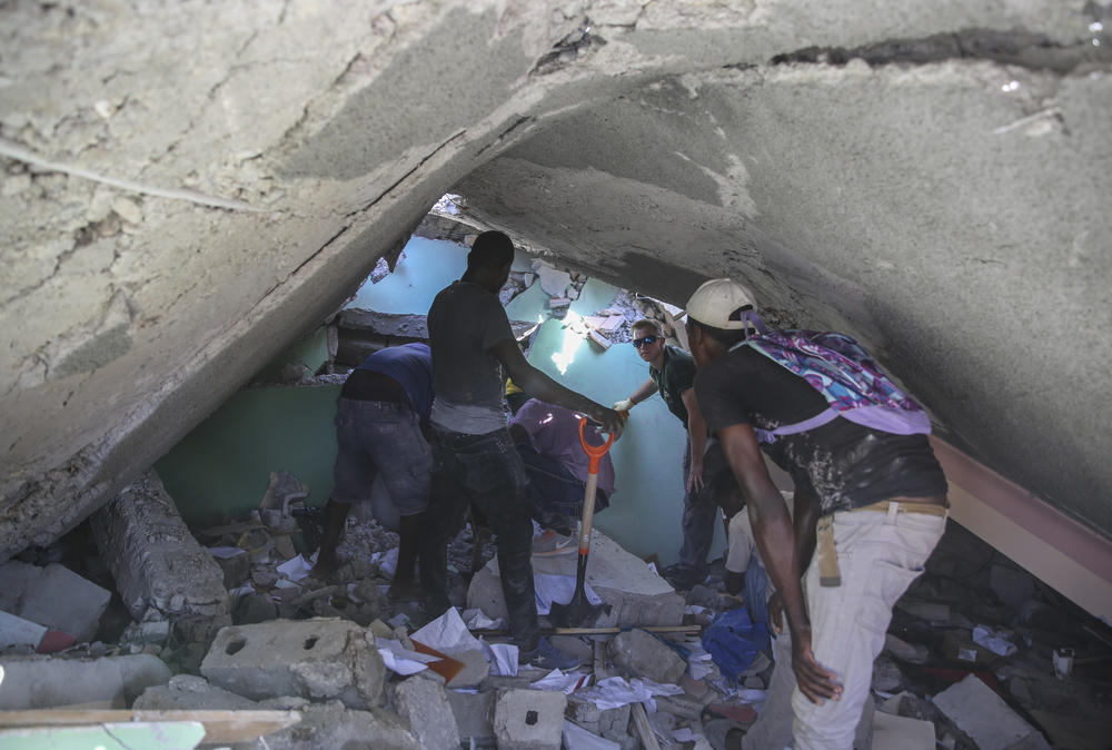 <strong>Sat., Aug. 14:</strong> People search for survivors in a home destroyed by the earthquake in Les Cayes, Haiti.
