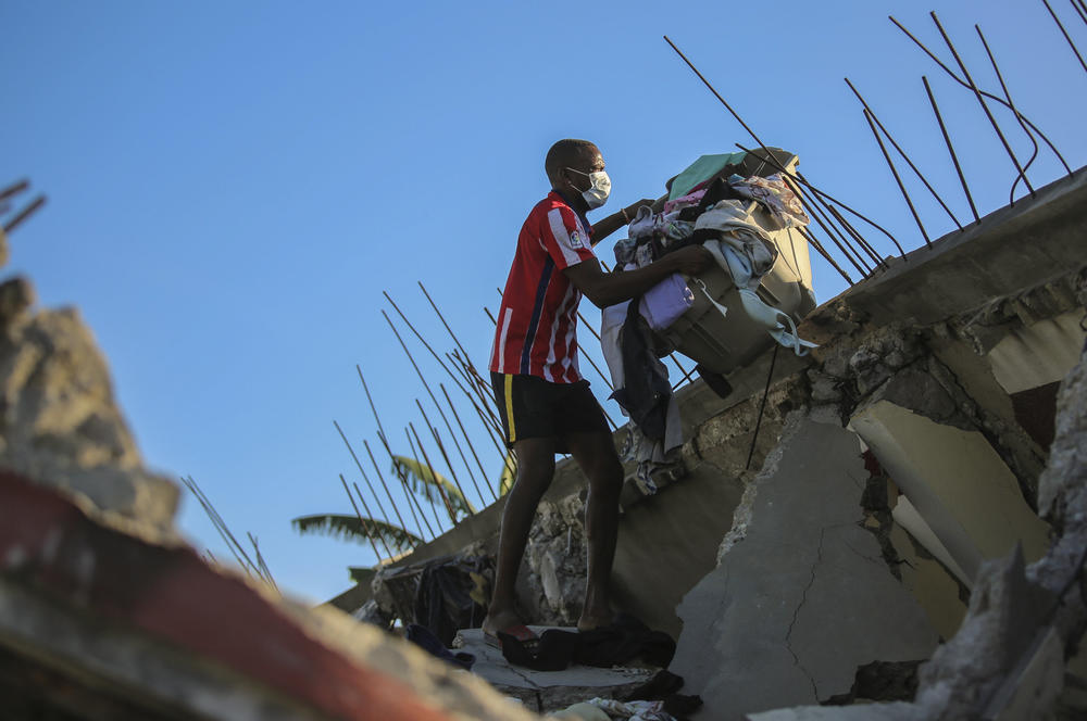 <strong>Sat., Aug. 14:</strong> A man recovers belongings from his home that was destroyed by the earthquake in Les Cayes, Haiti.