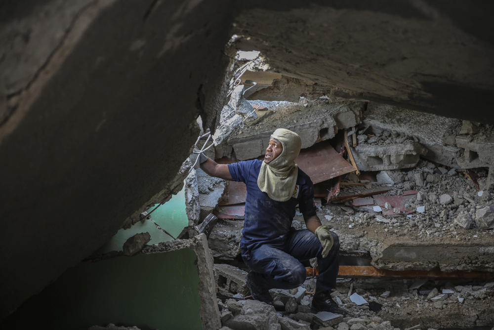 <strong>Sun., Aug. 15:</strong> A firefighter searches for survivors inside a damaged building, after Saturday´s 7.2 magnitude earthquake in Les Cayes.