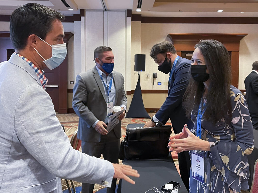 Jen Easterly, director of the Department of Homeland Security's Cybersecurity and Infrastructure Security Agency, speaks with Ohio Secretary of State Frank LaRose, left, during the summer meeting of the National Association of Secretaries of State.