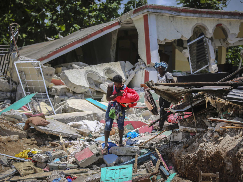 Locals recover their belongings Sunday from their homes destroyed in the earthquake in Camp-Perrin in Les Cayes, Haiti.