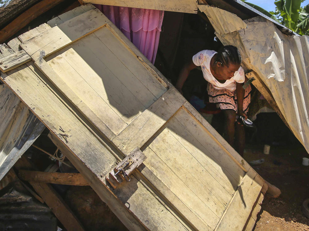 A woman tries to recover her belongings Sunday amid the rubble of her home destroyed by the quake in Camp-Perrin in Les Cayes.