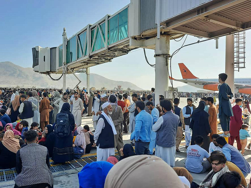 Afghans crowd the tarmac of the Kabul airport on Monday to flee the country. Thousands of people mobbed the city's airport trying to flee the group's feared hardline brand of Islamist rule.