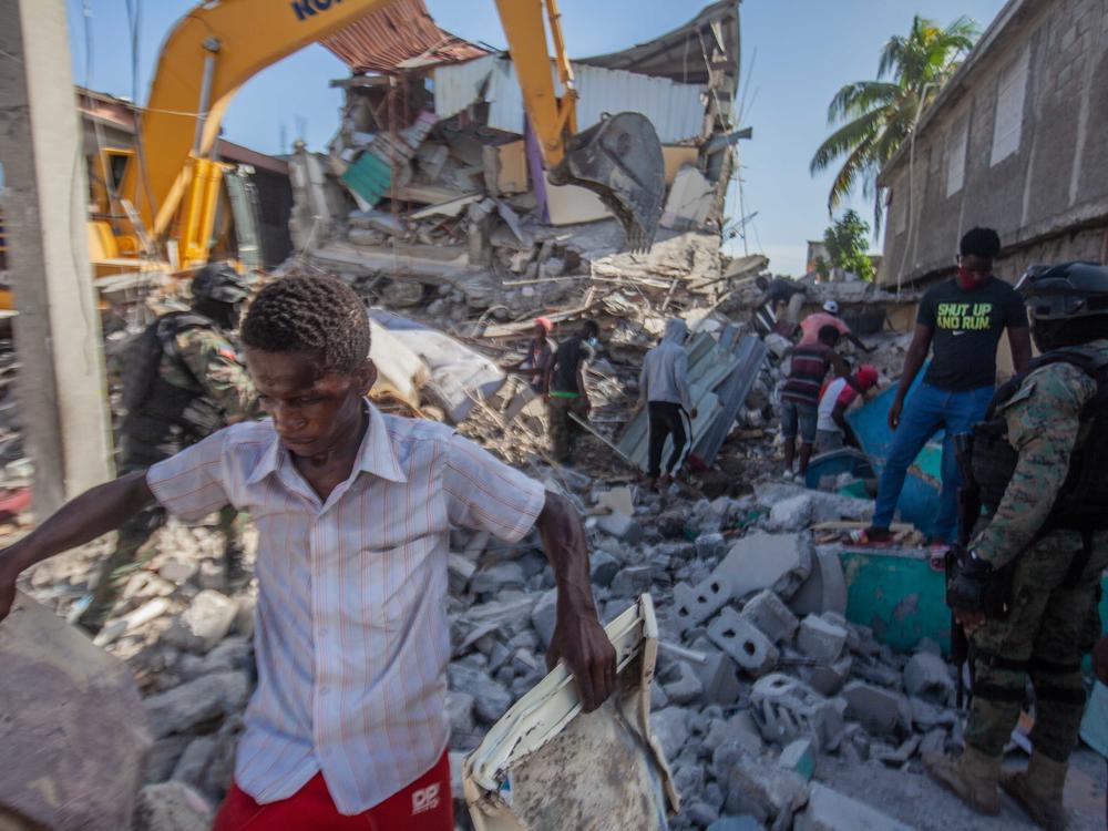 Haitians in Les Cayes assess the damage Sunday after a magnitude 7.2 earthquake struck a day earlier.