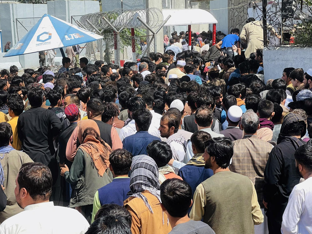 Afghans rush to the Hamid Karzai International Airport as they try to flee the Taliban takeover of Kabul.