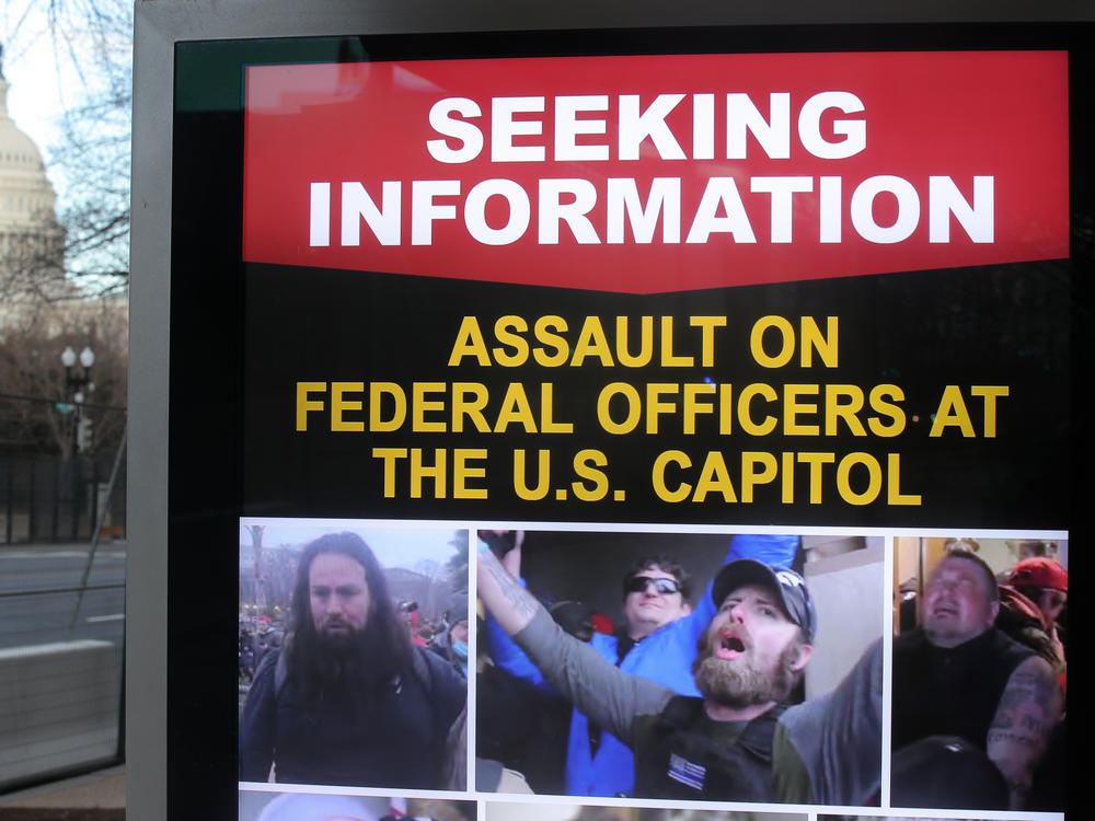 An information board shows people who are wanted by law enforcement on suspicion of assaulting federal officers at the U.S. Capitol during the Jan. 6 riot.