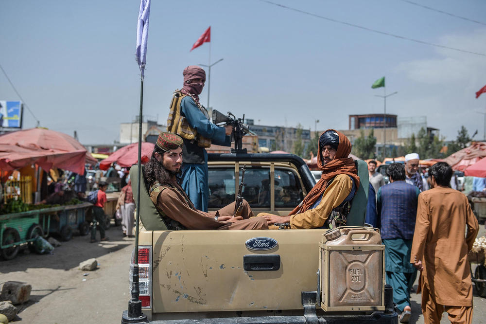 Taliban fighters on a pickup move around a market area Tuesday in Kabul.