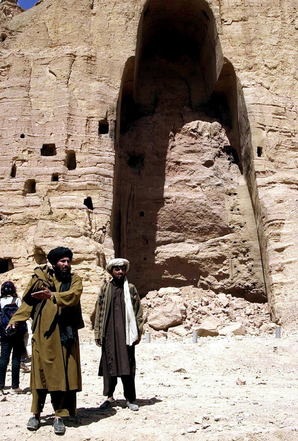 Afghan Taliban in front of the empty niche that held one of the two giant Buddha statues the Taliban blew up in Bamiyan in March 2001.