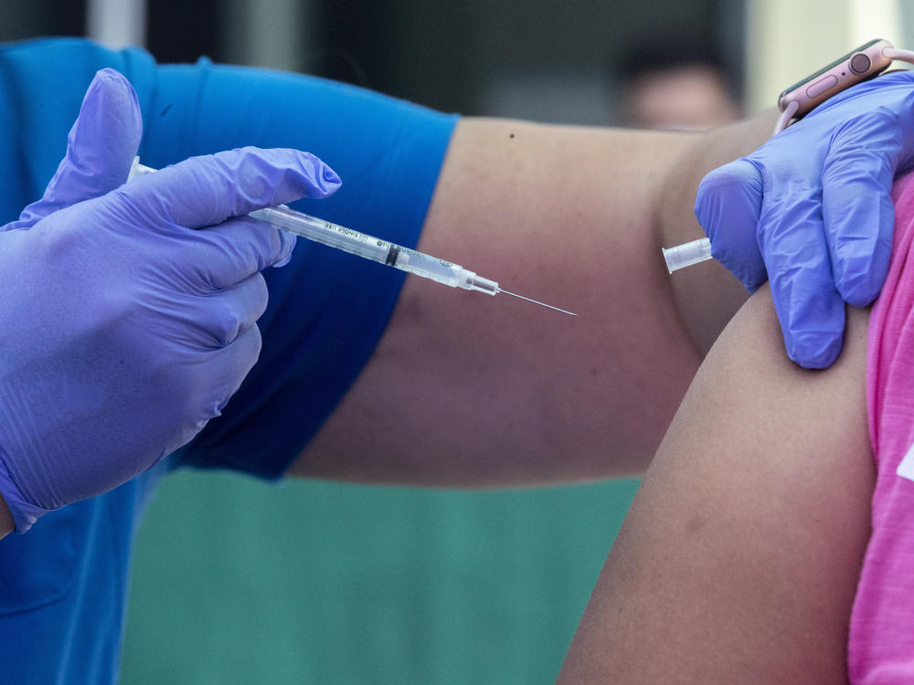RN Amy Berecz-Ortega, left, inoculates a woman at a COVID-19 vaccine event on Tuesday in Los Angeles, Calif.