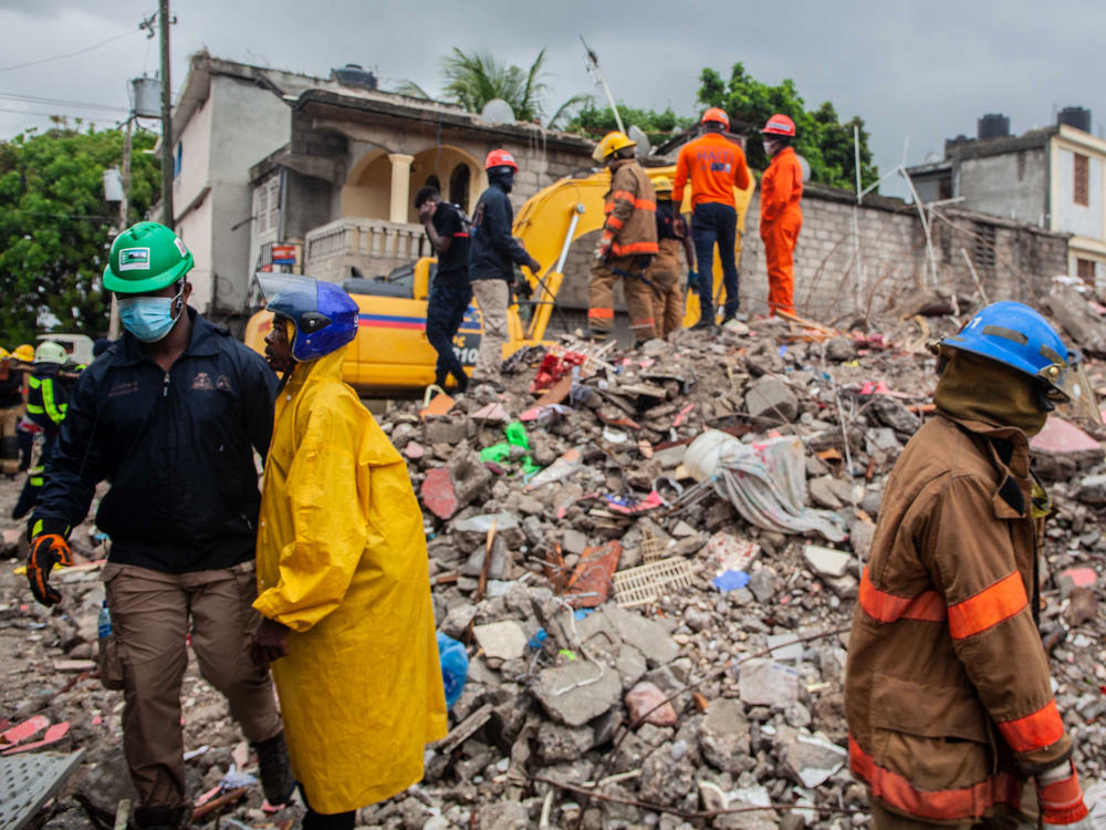 Firefighters remove debris while searching for survivors.