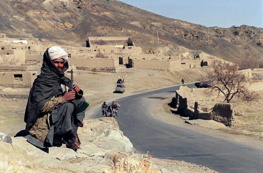 A Taliban fighter guards a road southeast of Kabul in 1995.