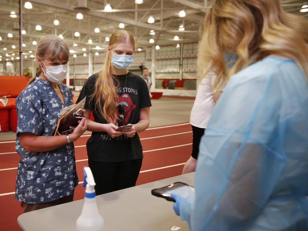 Phoebe Fies, a junior, and her mom Dixee Bartholomew-Feis, turn in her COVID-19 test during move-in week at the University of Nebraska-Lincoln.