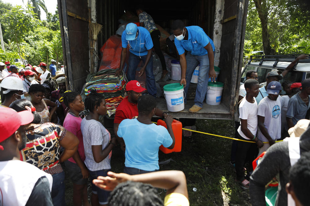 Relief workers with UNICEF and the Haitian Red Cross distribute supplies to people in Torbeck, Haiti.