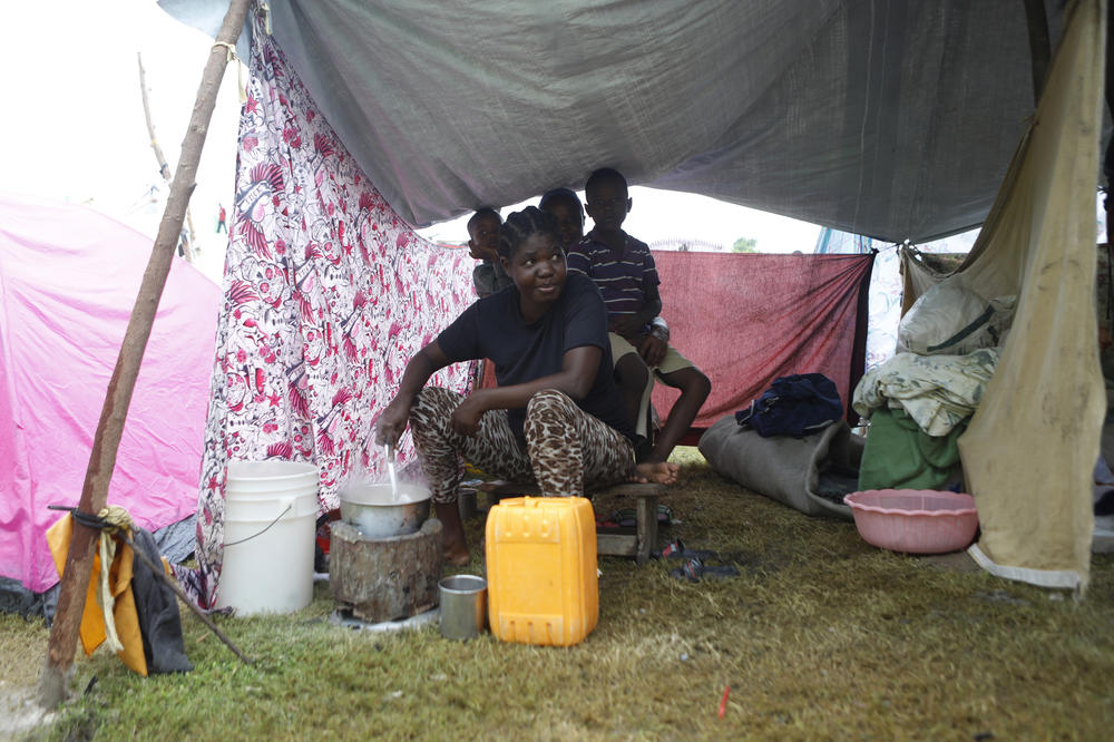 A woman cooks for her family while living in a makeshift tent at the soccer stadium. According to estimates from the U.N. Office for the Coordination of Humanitarian Affairs, 61,000 houses were destroyed by the earthquake.