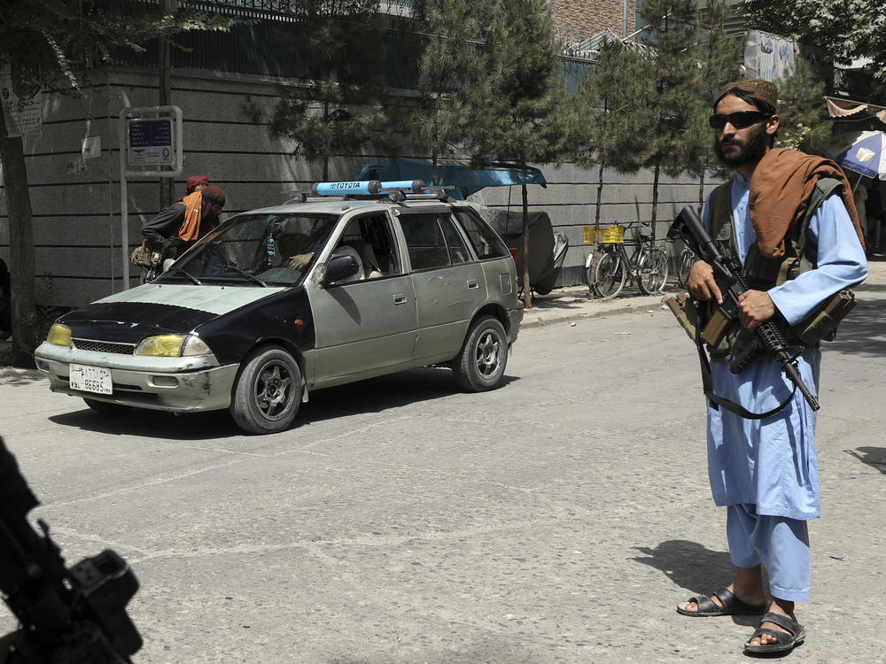 Taliban fighters stand guard at a checkpoint in the city of Kabul, Afghanistan, Wednesday, Aug. 18, 2021. The Taliban declared an 