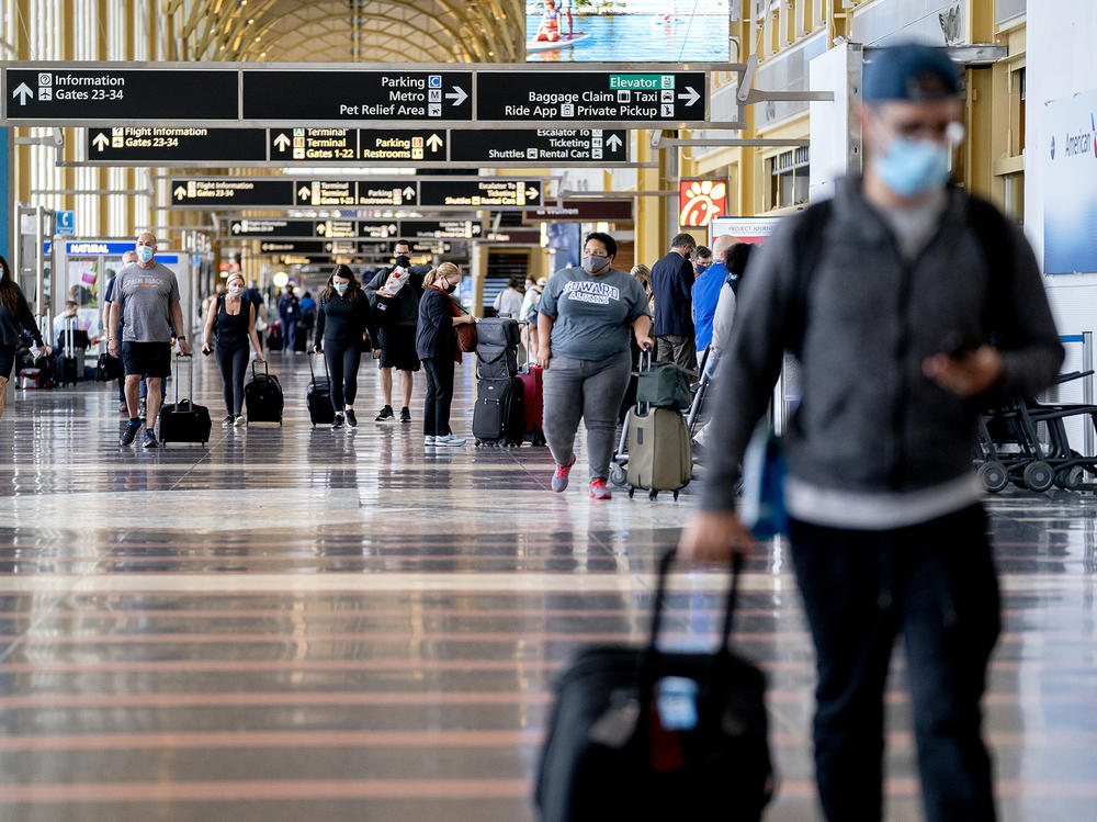 Mask-wearing travelers head through Reagan National Airport in Arlington, Va., in May. More than 70% of reports to the FAA of unruly passengers this year were related to people failing to comply with mask mandates and causing a disruption as a result.