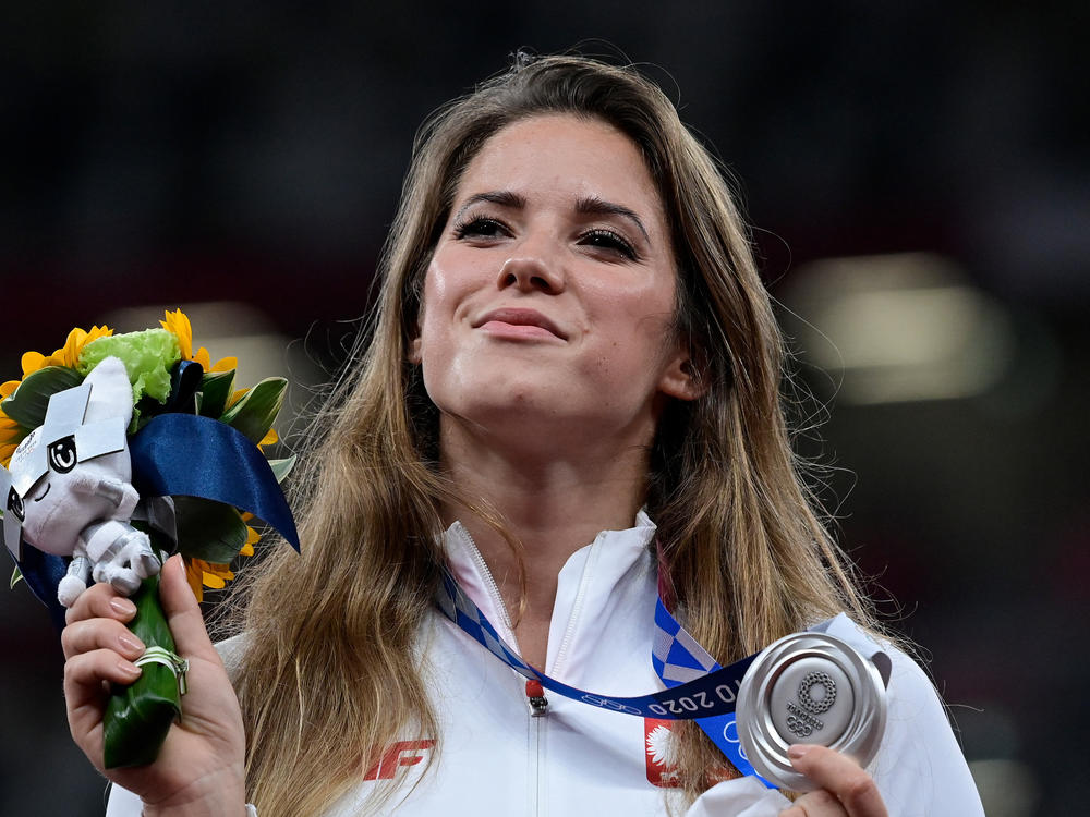 Poland's Maria Magdalena Andrejczyk celebrates her silver medal in the javelin throw at the Olympic Stadium in Tokyo on Aug. 7. She auctioned the medal to help fund heart surgery for an 8-month-old; the buyer decided to let her keep it.